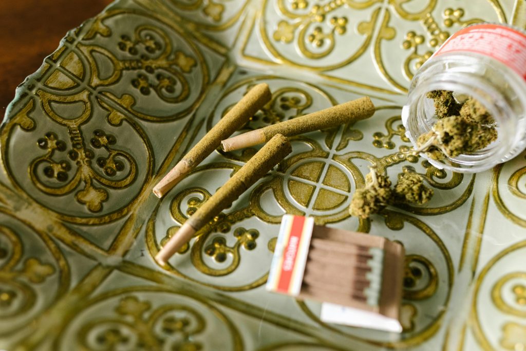Close-up of cannabis joints and buds on a decorative tray, embodying relaxation.